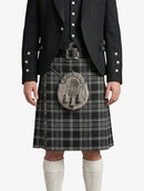 Person wearing a traditional Scottish kilt with a black jacket on a white background
