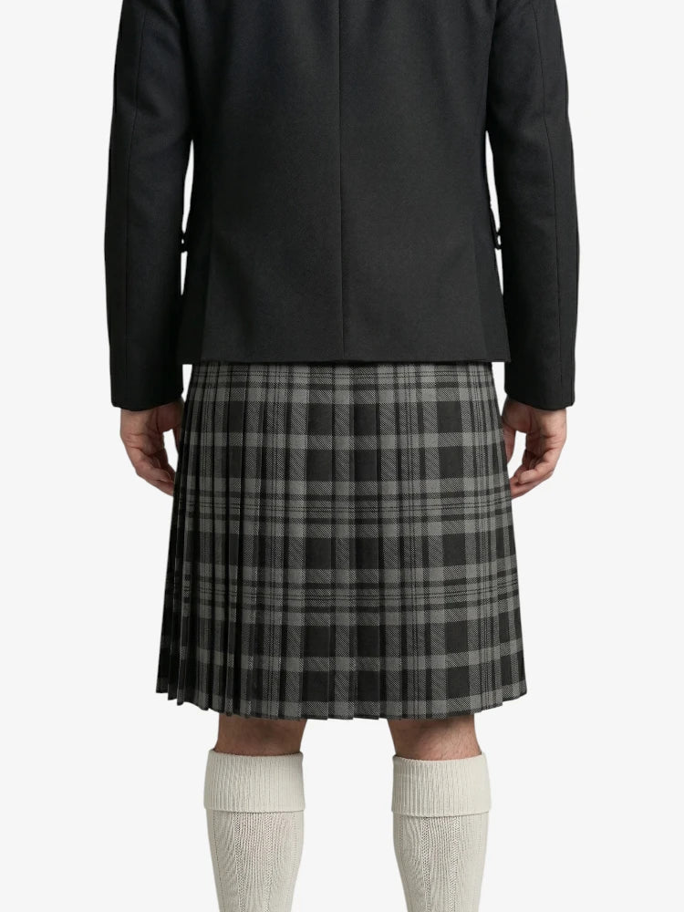 Person wearing a black coat and gray plaid kilt on a white background