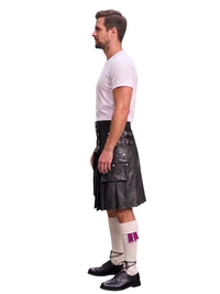 A man shown in profile wearing a black leather kilt, a white t-shirt, white socks with a purple accent, and black shoes, against a plain white background.