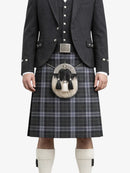 Person wearing a traditional Scottish kilt with a jacket and waistcoat on a white background