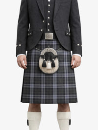 Person wearing a traditional Scottish kilt with a jacket and waistcoat on a white background