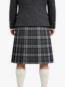 Person wearing a gray coat and plaid kilt on a white background