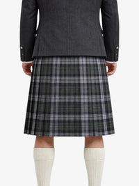 Person wearing a gray coat and plaid kilt on a white background
