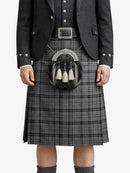 Person wearing a traditional Scottish kilt with a sporran on a white background