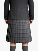 Person wearing a gray jacket with a plaid kilt on a white background