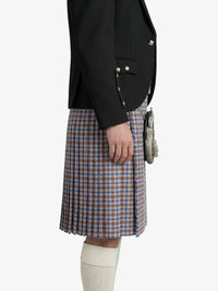 Person wearing a black blazer and plaid kilt on a white background