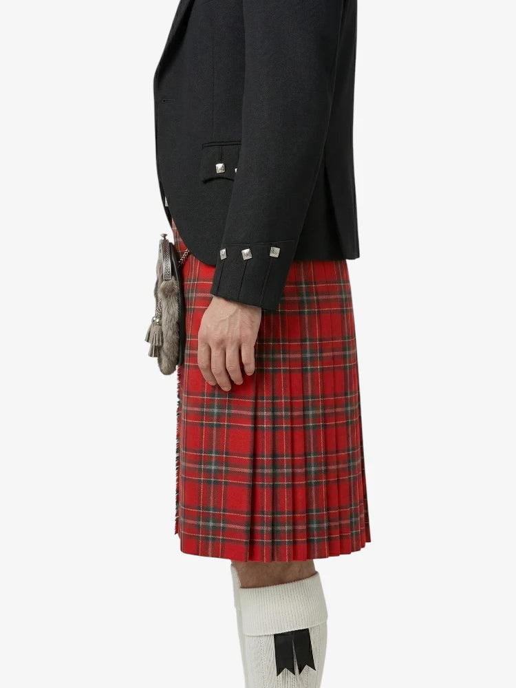 Person wearing a black jacket and red plaid kilt on a white background