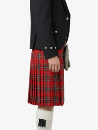 Person wearing a black jacket and red plaid kilt on a white background