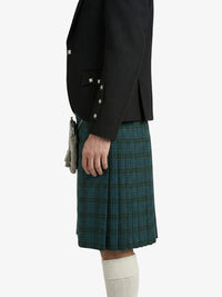 Person wearing a black jacket and green plaid kilt on a white background