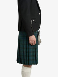 Person wearing a black blazer and green plaid kilt on a white background