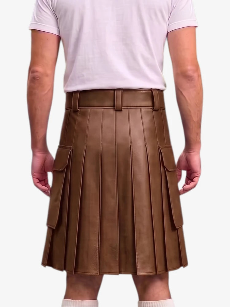 A person shown from the back wearing a brown pleated faux-leather kilt with side cargo pockets, paired with a light pink t-shirt and white socks, against a plain light gray background.