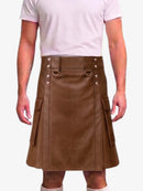 A man wearing a brown faux-leather kilt with silver-tone metal hardware and side cargo pockets, paired with a light pink t-shirt and white socks, against a plain white background.
