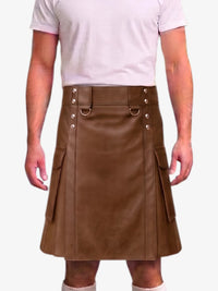 A man wearing a brown faux-leather kilt with silver-tone metal hardware and side cargo pockets, paired with a light pink t-shirt and white socks, against a plain white background.