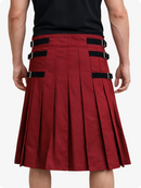 Burgundy pleated skirt with black straps worn by a person on a white background
