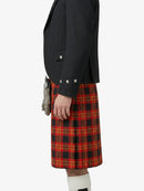 Person wearing a black blazer and red plaid kilt on a white background