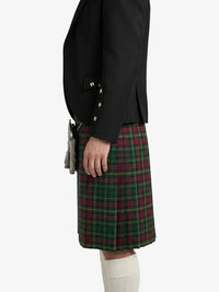 Person wearing a black jacket and green plaid kilt on a white background