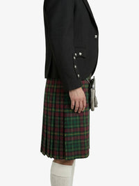 Person wearing a black blazer and green plaid kilt on a white background