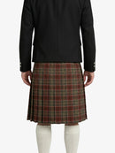 Person wearing a black jacket and plaid kilt on a white background