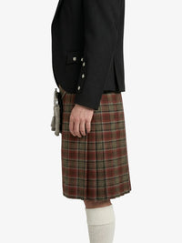 Person wearing a black jacket and plaid kilt on a white background