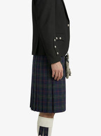 Person wearing a black blazer and plaid kilt on a white background