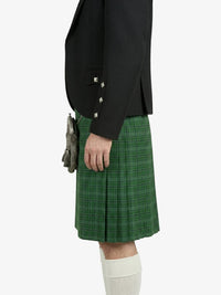 Person wearing a black jacket and green plaid kilt on a white background