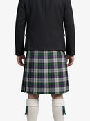 Person wearing a black jacket and green plaid kilt on a white background