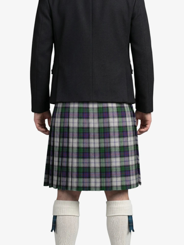 Person wearing a black jacket and green plaid kilt on a white background