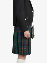 Person wearing a black blazer and green plaid kilt on a white background