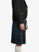 Person wearing a black blazer and blue plaid kilt on a white background