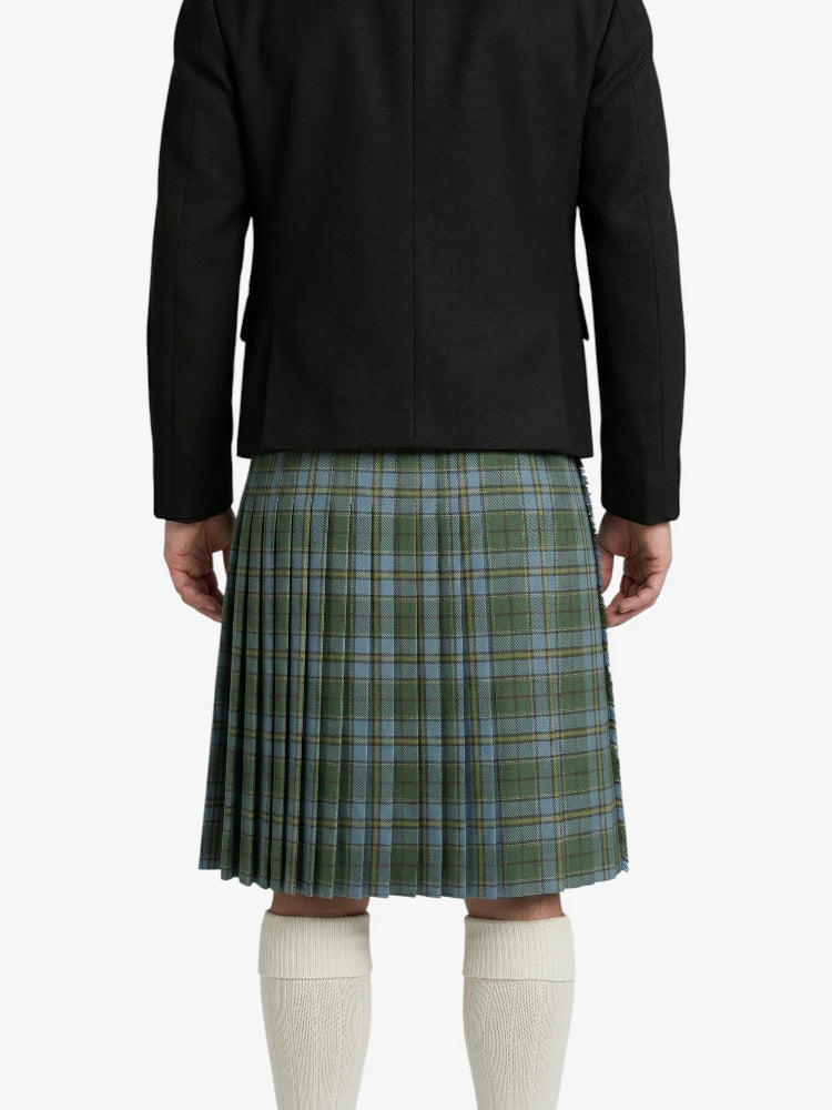Person wearing a green plaid kilt with a black jacket on a white background