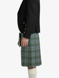 Person wearing a black jacket and green plaid kilt on a white background