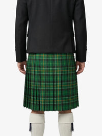 Person wearing a green plaid kilt with a black jacket on a white background