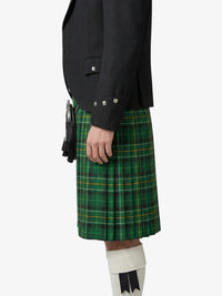 Person wearing a green plaid kilt with a black jacket on a white background