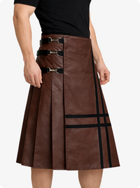 Brown leather skirt with black buckles worn by a person on a white background
