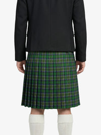 Person wearing a black jacket and green plaid kilt on a white background