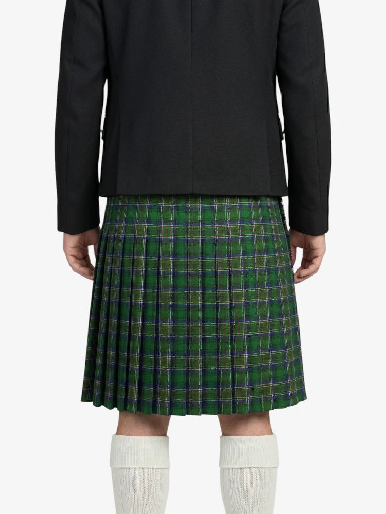 Person wearing a black jacket and green plaid kilt on a white background