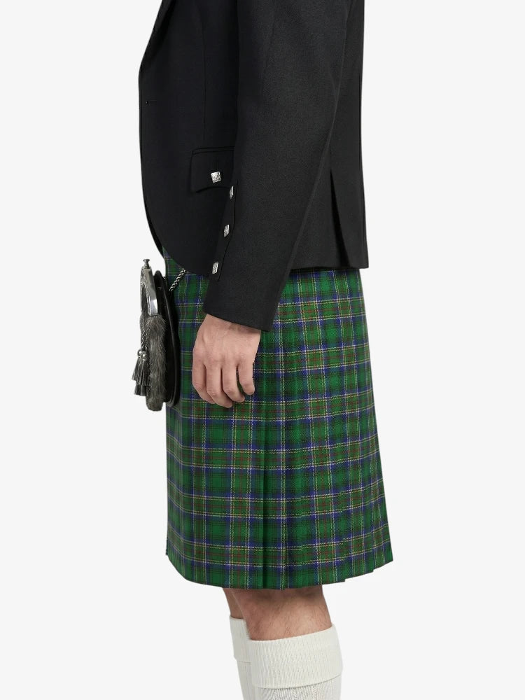 Person wearing a black jacket and green plaid kilt on a white background