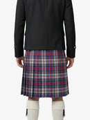 Person wearing a black jacket and plaid kilt on a white background