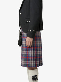 Person wearing a black blazer and plaid kilt on a white background