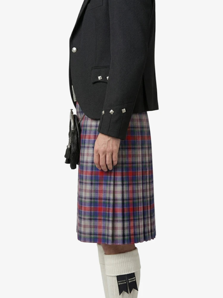 Person wearing a black blazer and plaid kilt on a white background