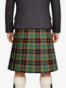 Person wearing a gray blazer and green plaid kilt on a white background
