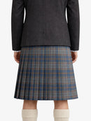 Person wearing a dark gray jacket and plaid kilt on a white background