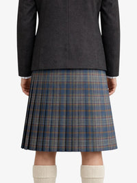 Person wearing a dark gray jacket and plaid kilt on a white background