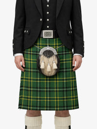Person wearing a traditional Scottish kilt with a green plaid pattern on a white background