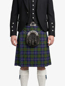 Person wearing a traditional Scottish kilt with a tartan pattern on a white background