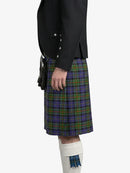 Person wearing a black jacket and plaid kilt on a white background