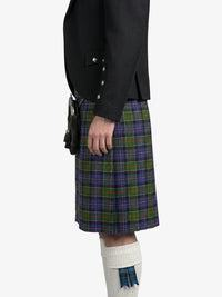 Person wearing a black jacket and plaid kilt on a white background
