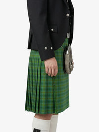 Person wearing a black jacket and green plaid kilt on a white background
