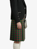 Person wearing a black jacket and green plaid kilt on a white background