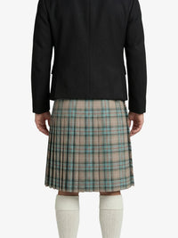 Person wearing a black jacket and plaid kilt on a white background